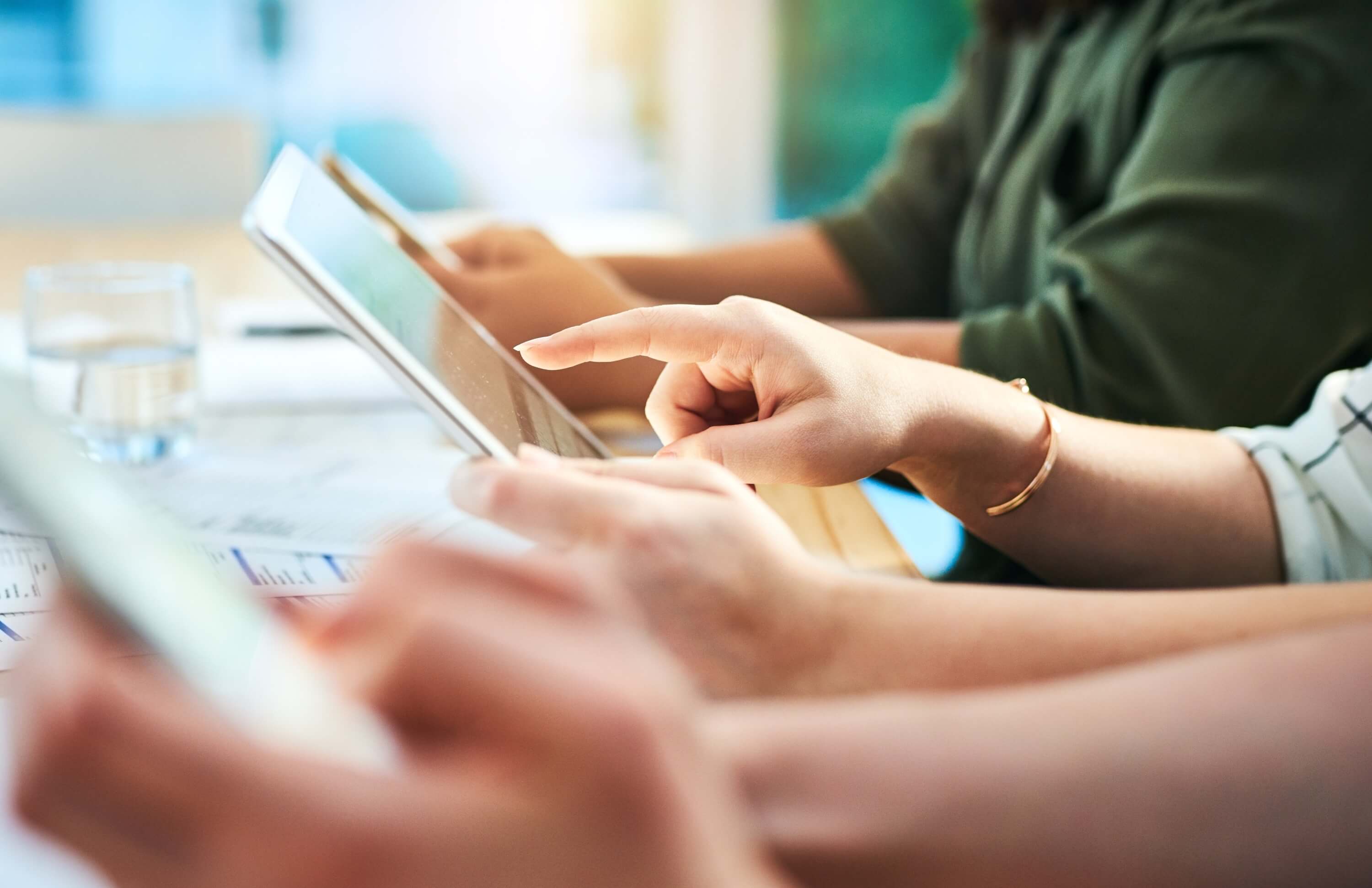 Hands using tablets in a collaborative setting, related to inventory management and secure client portals.