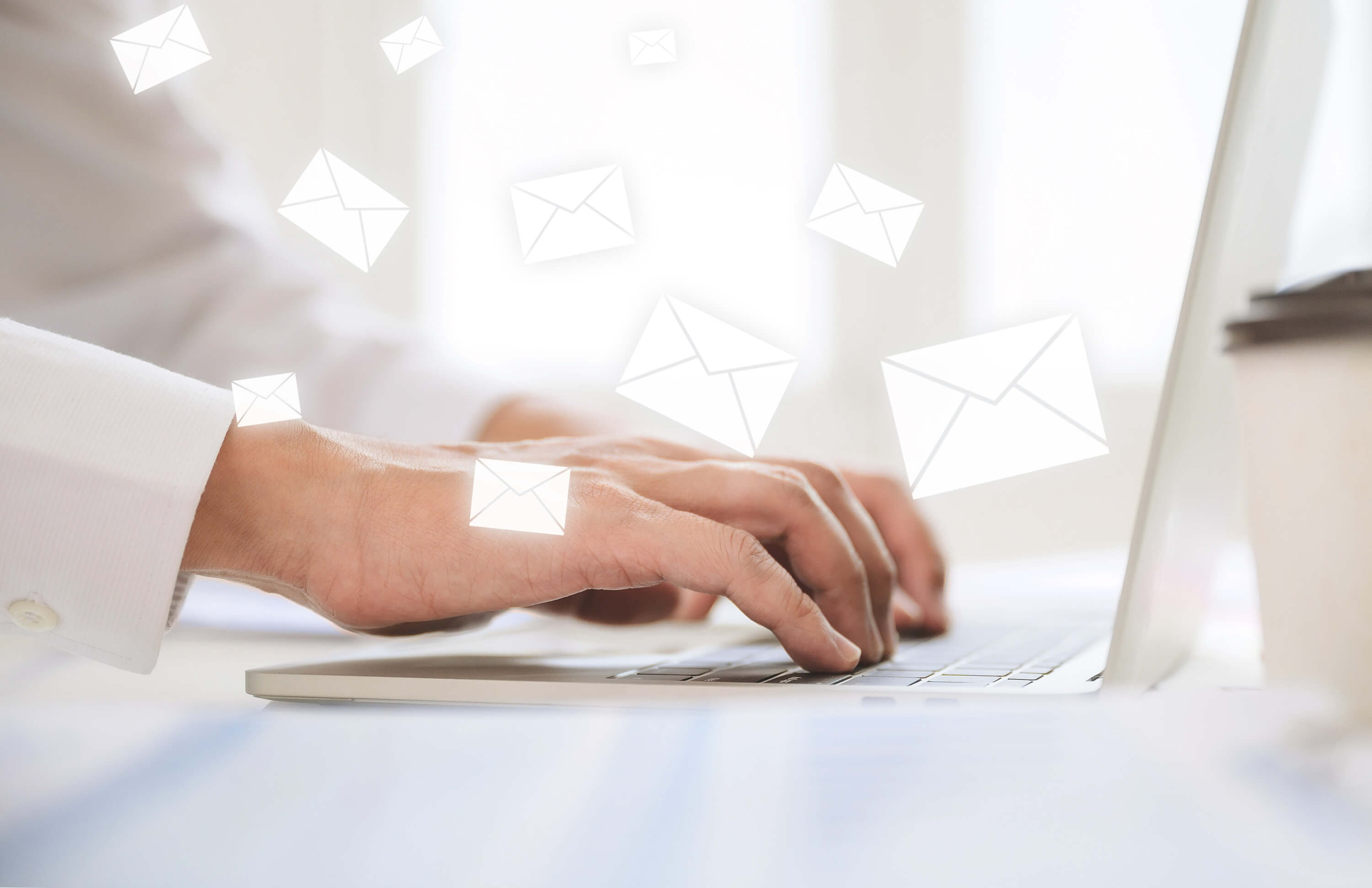 Hands typing on a laptop with floating email icons, illustrating personalized email marketing for exclusive offers.