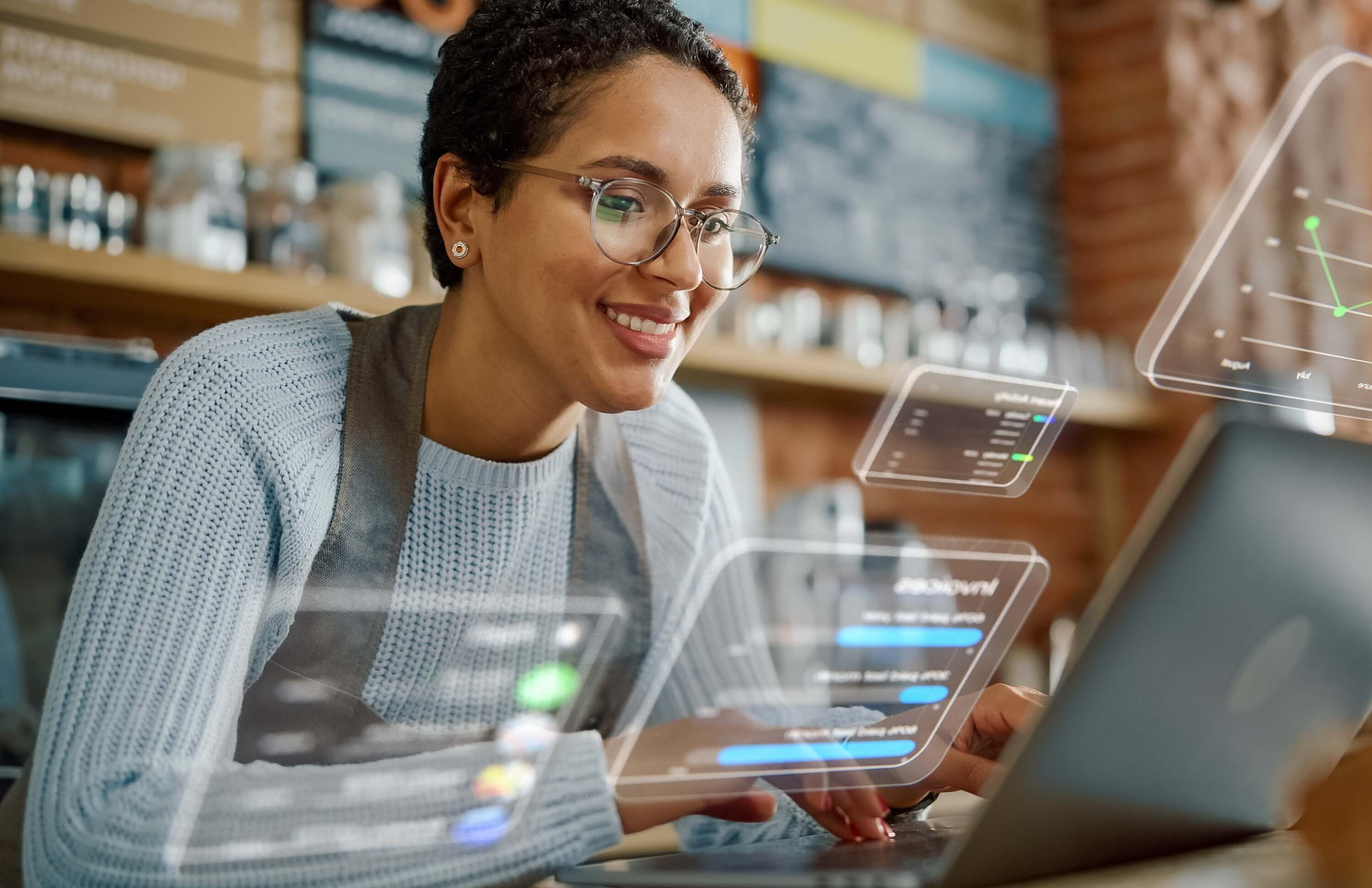 Retail worker using a laptop with floating analytics dashboards, illustrating streamlined inventory management.