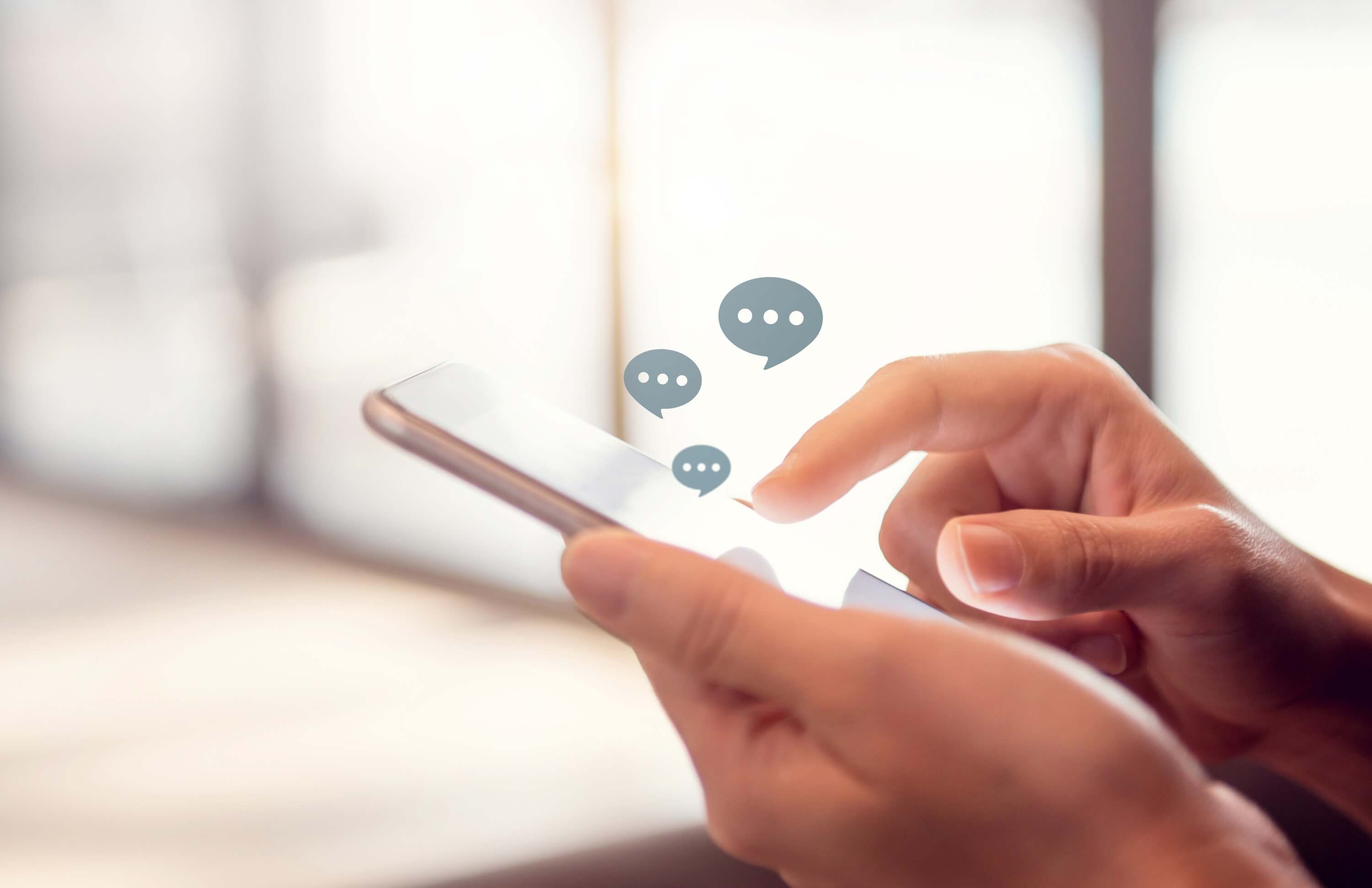 User interacting with a smartphone displaying chat bubbles, illustrating AI-driven personalization.